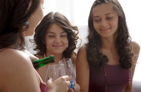 Девушки-лесбиянки принимают участие в сексе втроем, распивая бутылку спиртного 12