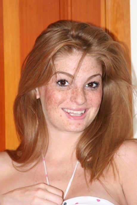 Рыжая с веснушками обнажает свои увеличенные сиськи, прежде чем потрогать пальцами свою розовую киску 2