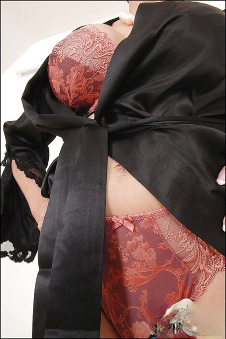 Длинноногая зрелая леди на высоких каблуках позирует в шелковой ночной рубашке и нижнем белье 7