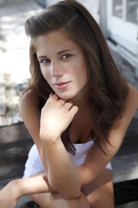 Симпатичная молоденькая малышка Каприс показывает свои маленькие сиськи и лысую киску возле коттеджа 1