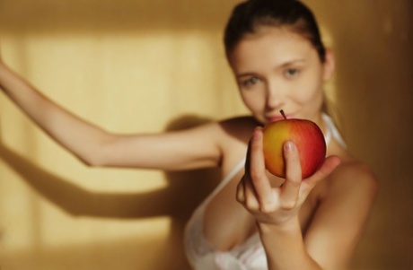 Красивая девушка-подросток показывает свои большие сиськи и лысую пизду, поедая фрукты 1