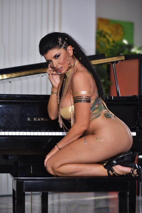 Сексуальная милфа Роми Рейн обнажает свои большие сиськи и киску на скамейке у пианино 4