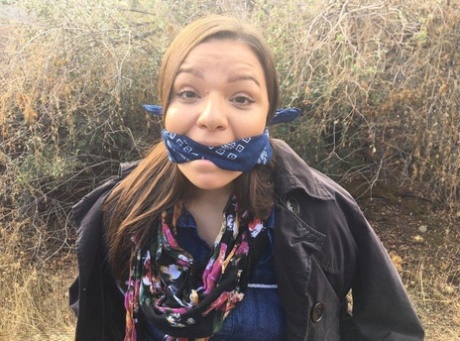 Полностью одетый толстяк расколот, с кляпом во рту и связанный веревкой в заросшем кустарником лесу 1