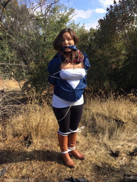 Полностью одетый толстяк расколот, с кляпом во рту и связанный веревкой в заросшем кустарником лесу 5