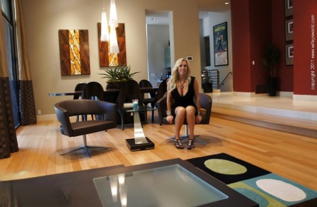 Великолепная блондинка на высоких каблуках обнажает свои большие сиськи и киску 1